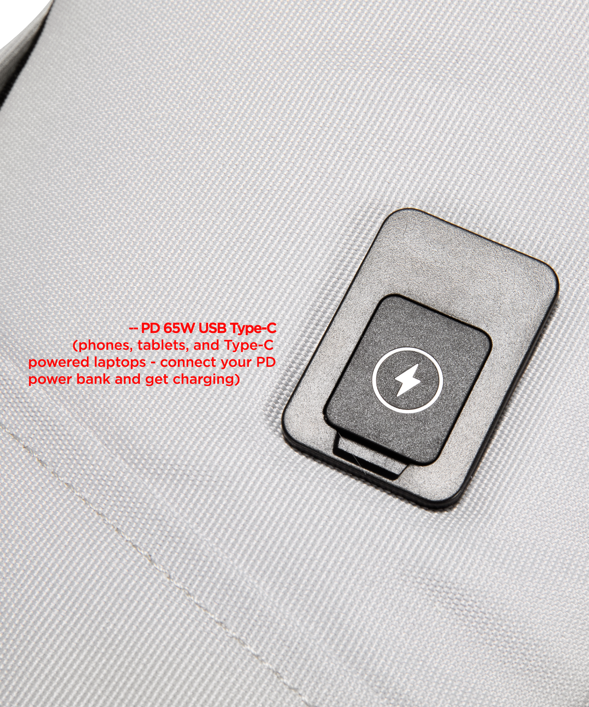 Close-up of a White/Grey fabric bag with a USB C Port attached with a white lightning bolt symbol and red text explaining USB-C charging compatibility.