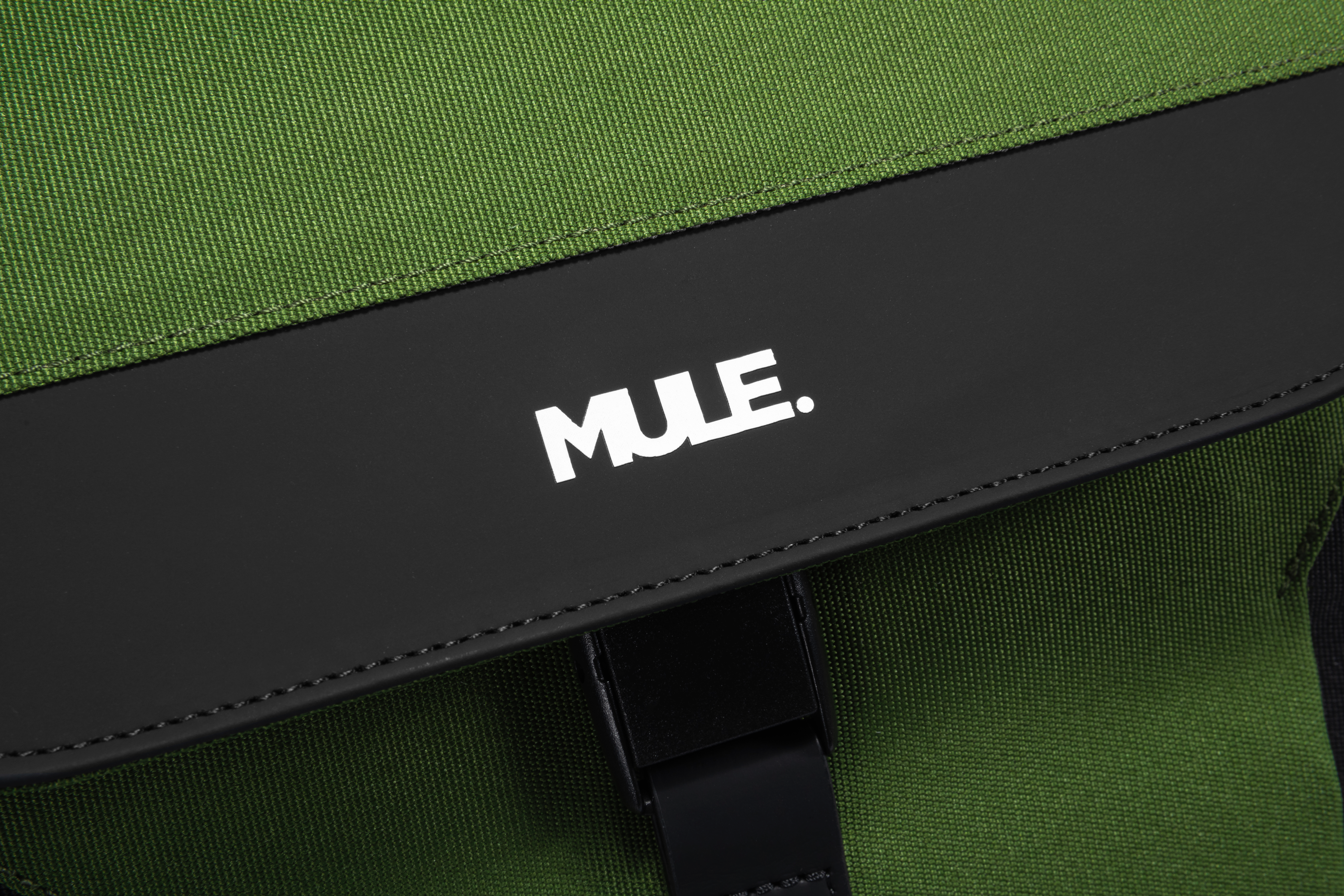 Green bag with a black strap displaying the 'MULE' brand logo.